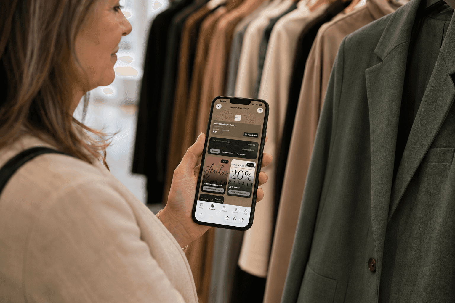 Woman browsing a fashion app on her smartphone in a clothing store.